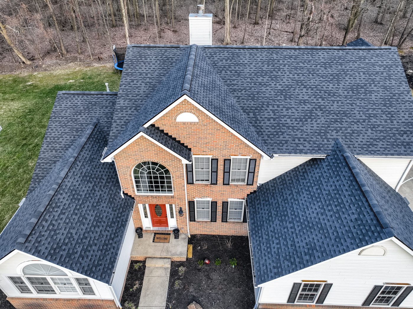 Aerial drone photo of a completed dark architectural-shingle roof on a two-story brick home in Northeast Ohio